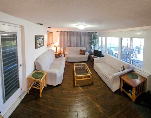 a living room with two white couches and a table at Private Tropical Waterfront Sanctuary w pool, hot tub & an island! Pet Friendly in New Port Richey