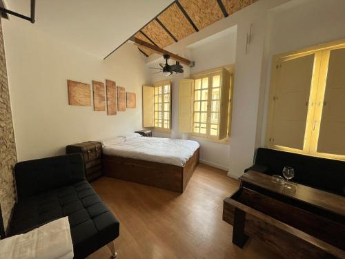 1 dormitorio con cama, sofá y ventanas en LUXURY APARTMENTS CHINITAS 11, en Málaga