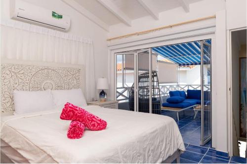 a bedroom with a bed with red shoes on it at Marazul D1 in Westpunt