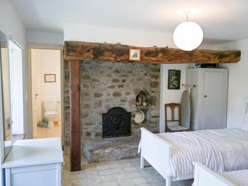 um quarto com uma lareira de pedra em frente a uma cama em Gite Le Chevalier em Gavray