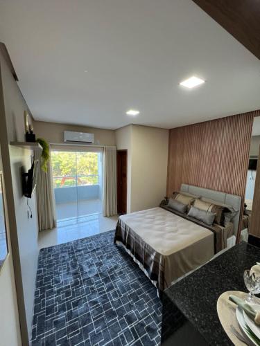 Un dormitorio con una cama y una ventana grande. en Flat Moderno Ilha Bela, en Alter do Chao