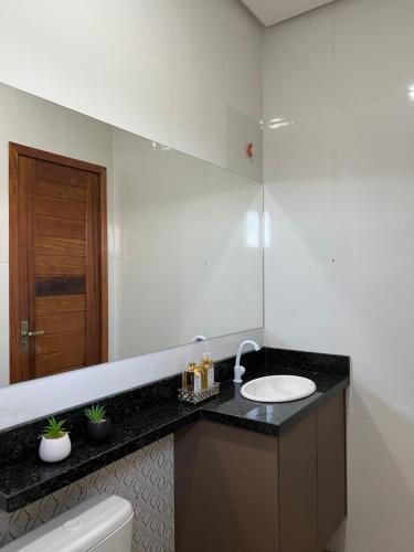 アウテル・ド・ションにあるFlat Moderno Ilha Belaのバスルーム(洗面台、鏡付)
