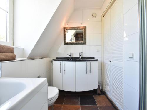 een badkamer met een wastafel en een toilet bij Villa Robinie in Oude-Tonge