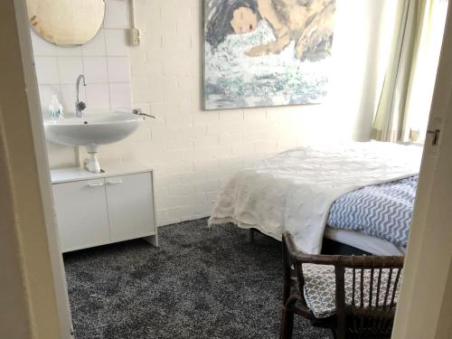 een badkamer met een wastafel en een bed naast een wastafel bij Huize Andriessen in Boornzwaag
