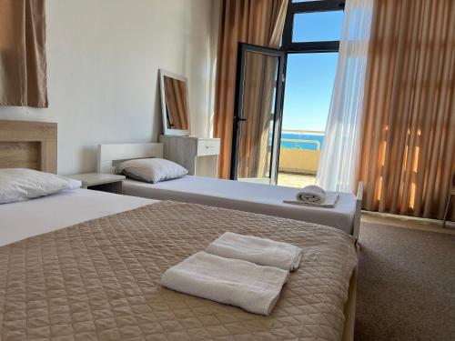 a hotel room with two beds and a large window at Apartments Nautilus in Ulcinj