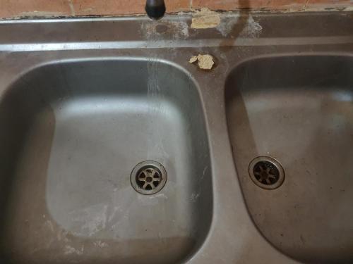 a stainless steel sink with two holes in it at Chambres individuelles et collectives à Setif in Sétif