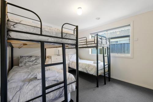 a bedroom with three bunk beds and a window at Shoalhaven Escape Cowes in Cowes