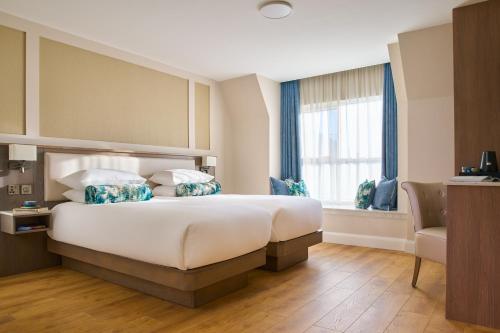 um quarto de hotel com uma cama grande e uma janela em The James Hotel em Tralee