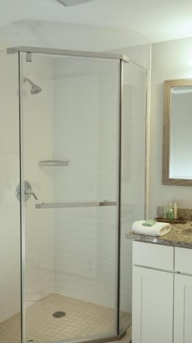 a shower with a glass door in a bathroom at Paniolo Greens Resort in Waikoloa