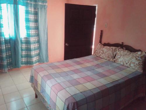 a bedroom with a bed with a checkered blanket at Port Antonio Residence in Port Antonio