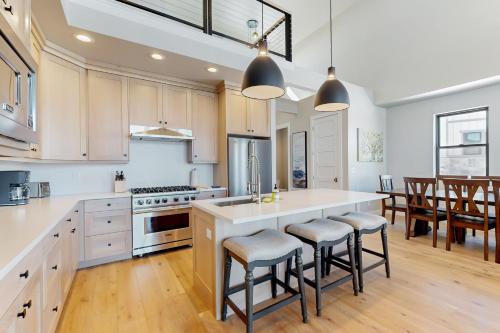 a kitchen with white cabinets and a island with bar stools at Sparkling Waters in Heber City