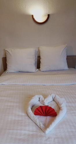 ein Herz aus Handtüchern auf einem Bett in der Unterkunft Isvara Restaurant & Hotel in Breteuil