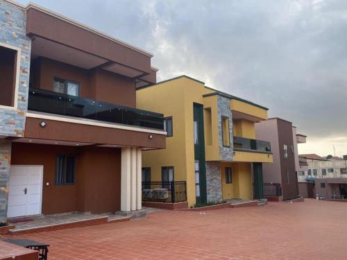 a group of buildings in a parking lot at Cozy Lux Apartments by Harolty in Kumasi