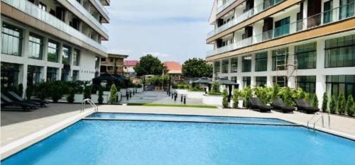 a large swimming pool in front of a building at The Signature Hotel Apartment Accra Ghana in Accra