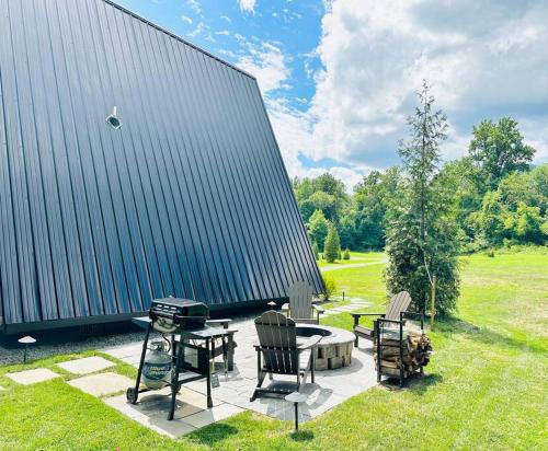 a patio with chairs and a table and a grill at Unique a frame cabin located near Old Rag Mountain in Etlan