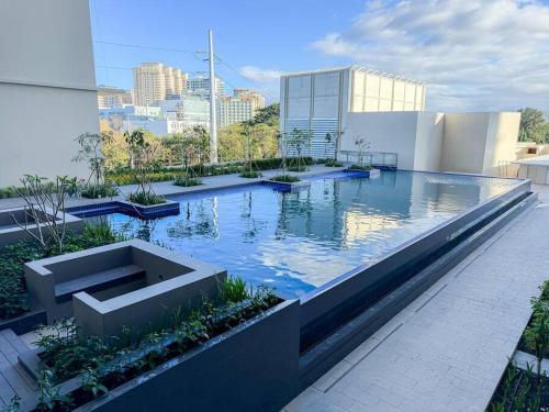 una piscina en la parte superior de un edificio en A2J Luxury 1BR Suite Near Venice Mall BGC Taguig en Manila