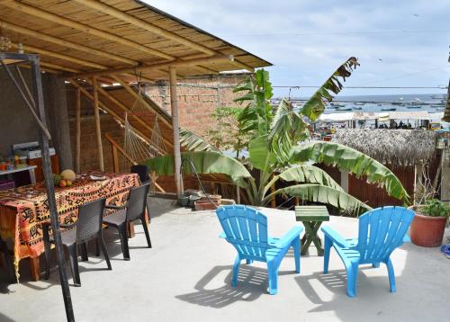 un patio con sillas azules, una mesa y una mesa con sillas en Casa de Heidi, en Puerto López