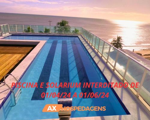 a swimming pool on top of a building next to the ocean at Blue Sunset Prime com vista para mar in João Pessoa