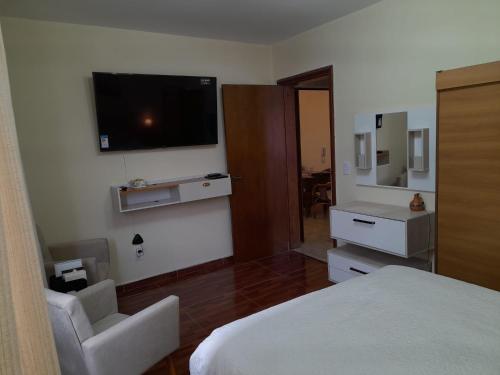 a hotel room with a bed and a television on the wall at Condominio Binacional in Santana do Livramento