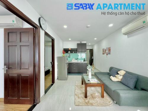 a living room with a blue couch and a table at Sabay Airport Apartment - The Connect in Ho Chi Minh City