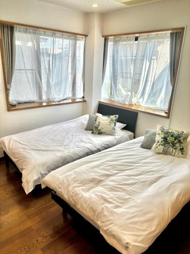 two beds in a room with two windows at Koiwa Detached house 小岩駅にある戸建のおうち in Tokyo