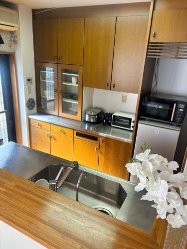 a kitchen with wooden cabinets and a sink at Koiwa Detached house 小岩駅にある戸建のおうち in Tokyo