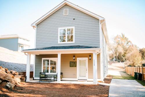 a house with a porch with a bench on it at Bright Artist's Cottage-Mins to Downtown, Campus in Athens