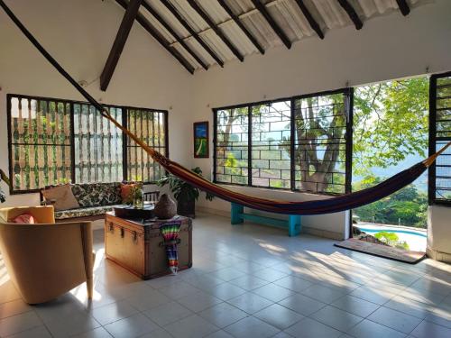a living room with a hammock in a room with windows at La Villa The View in Pance