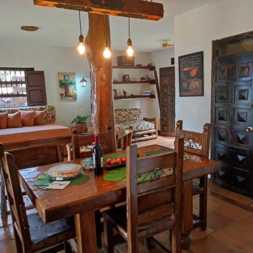 a kitchen and dining room with a wooden table and chairs at La Villa The View in Pance