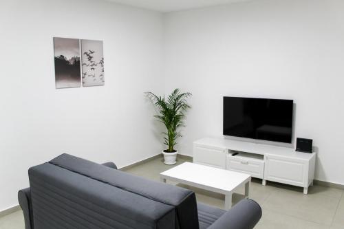 a living room with a couch and a tv at Luxury Family Apartment #30 By Hashdera Eilat in Eilat