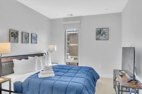 um quarto com uma cama azul e uma televisão em Fully Furnished Apartment in Washington near Logan Circle em Washington