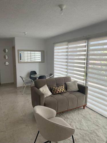 a living room with a couch and chairs at Departamento nuevo de estreno in Candelaria