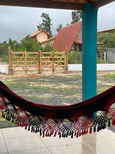a hammock in a yard with a wooden fence at Casa Azul do Capão in Palmeiras