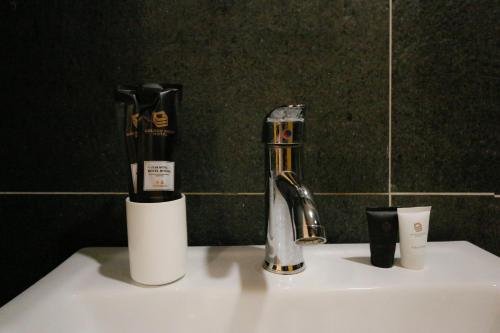 a bathroom sink with a toothbrush and a faucet at Golden Roof Hotel Sunway Ipoh in Ipoh