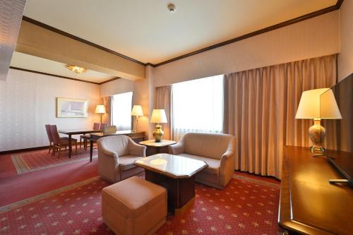 a hotel room with a couch and a table at Takamatsu Kokusai Hotel in Takamatsu