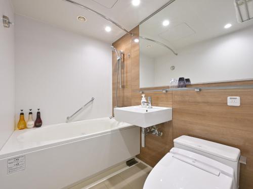 a bathroom with a sink and a tub and a toilet at Takamatsu Kokusai Hotel in Takamatsu