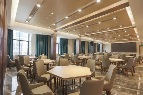 a waiting room with tables and chairs at Waiting Hotel - Jiande Xin'an River Riverside in Jiande