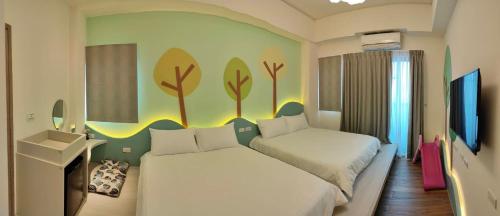 1 dormitorio con 2 camas y una pared con árboles en Mi Hai B&B, en Magong