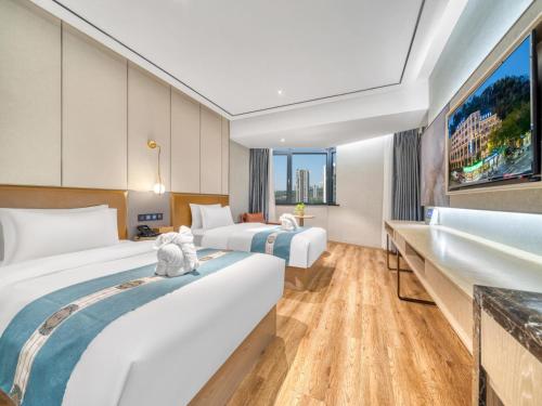 a hotel room with two beds and a large window at Waiting Hotel - Jiande Xin'an River Riverside in Jiande