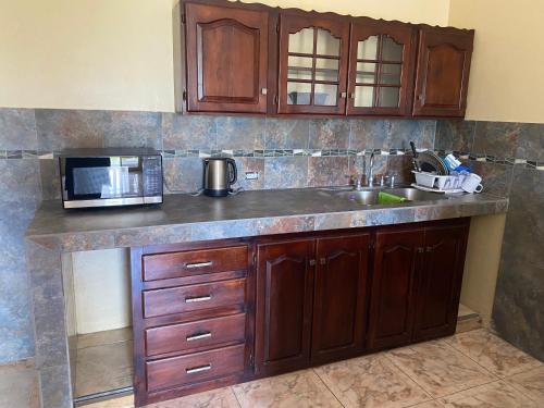 a kitchen counter with a sink and a microwave at Marshan villa in Montego Bay