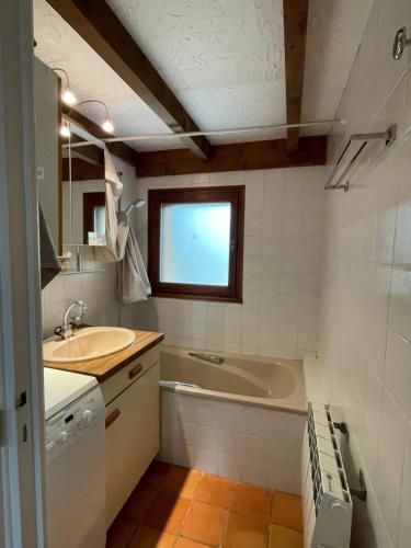 La salle de bains est pourvue d'un lavabo et d'une baignoire. dans l'établissement Appartement dans résidence avec piscine commune, à Sablet