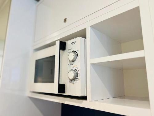 a white microwave oven sitting on a shelf at Luxury Aparthotel orbi in black sea arena in Batumi