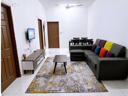 uma sala de estar com um sofá e uma televisão em HomeSTAY PANGSAPURI SAMUDERA SERI MANJUNG LUMUT em Seri Manjung