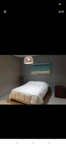 哥多華的住宿－Excelente casa, Ideal para Familia Fines de Semana，卧室配有白色的床和吊灯。