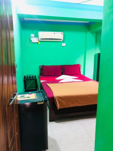 Cette chambre comprend un lit avec un mur vert. dans l'établissement Small Daddy Baga Beach, à Baga