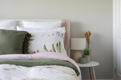 a bedroom with a bed with green and white pillows at Legana Lodge - A home away from home - Catering for up to 12 guests in Legana