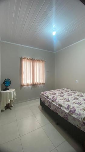 una camera da letto con un letto, una finestra e un tavolo di Casa Azul do Capão a Palmeiras