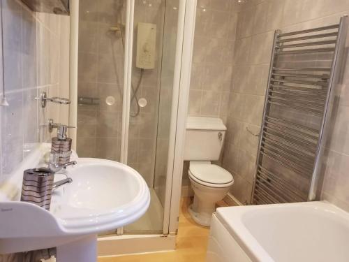 a bathroom with a sink and a toilet and a shower at Central Reading 4 Bedrooms 2Baths Free Parking in Reading