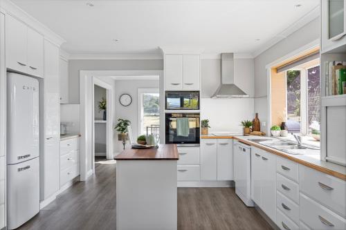 a kitchen with white cabinets and a counter top at Legana Lodge - A home away from home - Catering for up to 12 guests in Legana