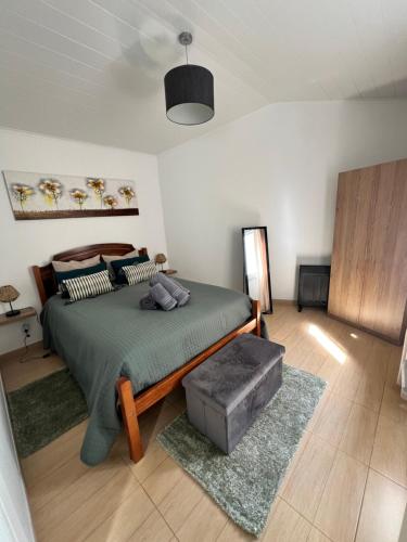 a bedroom with a bed with a green comforter at Casa da Cascata do Segredo in Praia